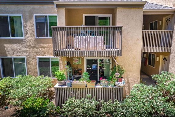 Front view of a building with balconies and potted plants.