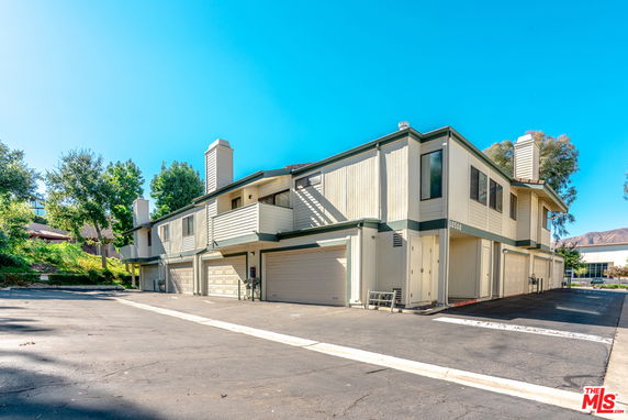 Front view of a two-story residential building with multiple garages.