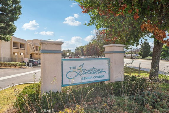 Entrance view of a condominium complex with a sign reading 'The Fountains Senior Condos'.