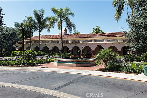 Front view of a Mediterranean-style building with arched colonnades and a tiled roof.