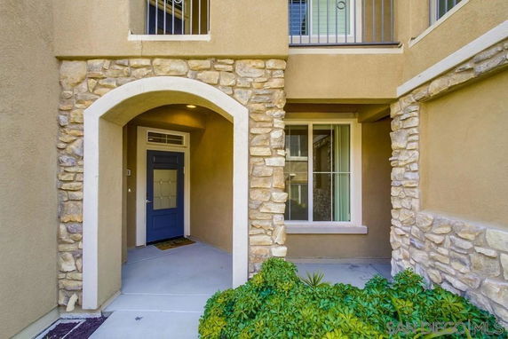 Entrance of a house with a stone archway and a blue door.