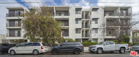 Front view of a multi-story apartment building with balconies.