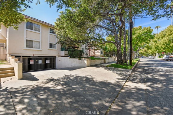 Front view of a multi-story residential building with parking area at the base.