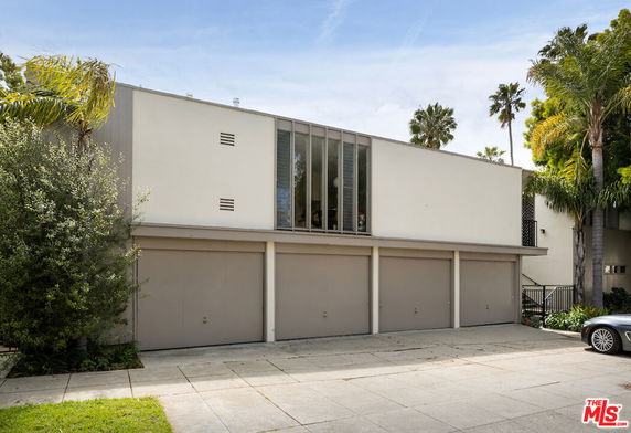 Front view of a two-story house with a row of garages.