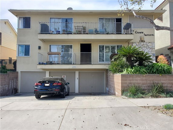 Front view of a multi-story building with balconies and a double garage.