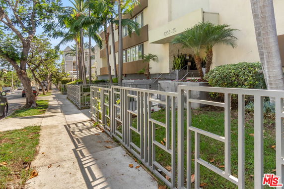 Front view of a multi-story building with a landscaped entrance.