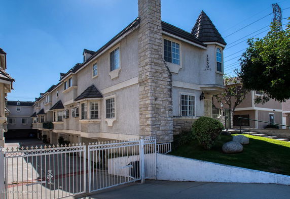 Front view of a multi-story residential building with gated entrance.