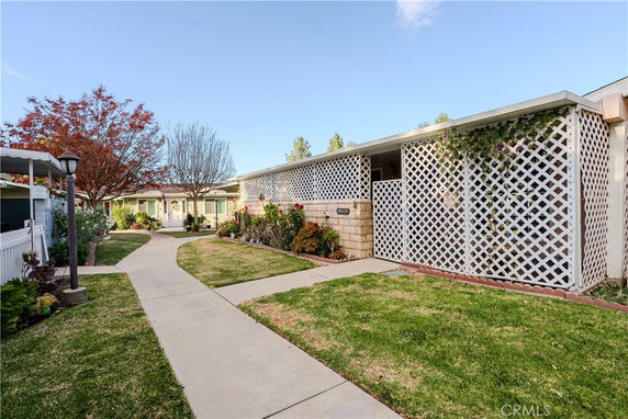 Front view of a single-story house with a lattice fence and small garden.