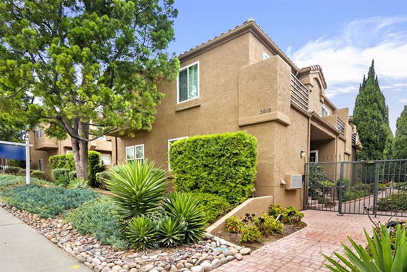 Front view of a two-story residential building with a gated entrance.