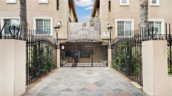 Front view of a multi-story building with a gated entrance.