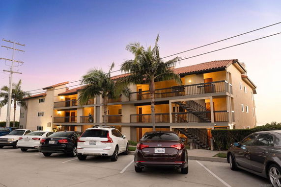 Front view of a multi-story apartment building with exterior staircases.