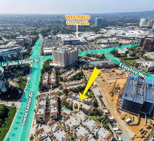Aerial view of a city area with a mix of buildings, roads, and construction site.