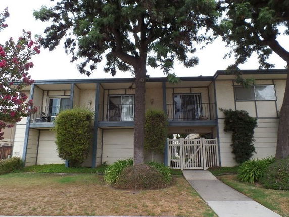 Front view of a two-story building with balconies and a central entrance.