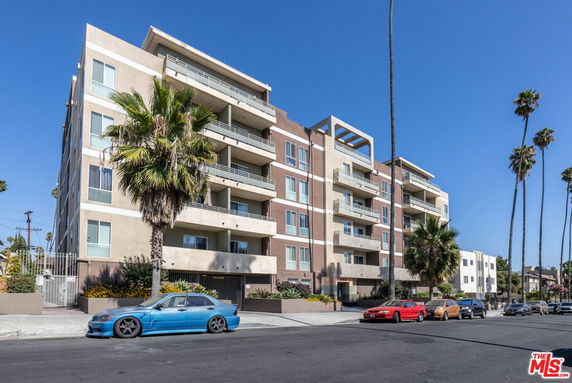 Front view of a multi-story apartment building with balconies.