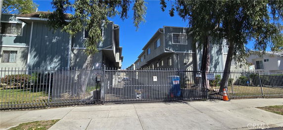 Front view of a multi-story residential building with gated entrance.