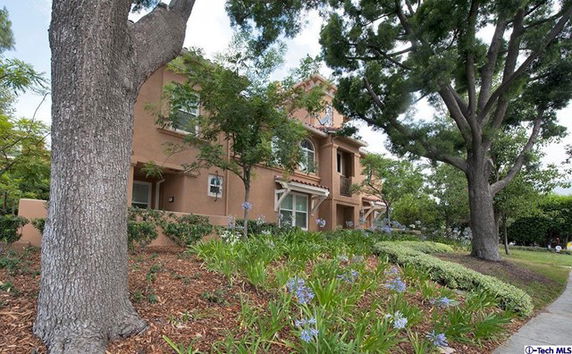 Front view of a two-story house with a beige exterior and arched windows.