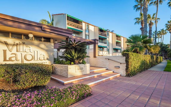 Front view of a multi-story condominium complex with a sign reading 'Villa La Jolla.'