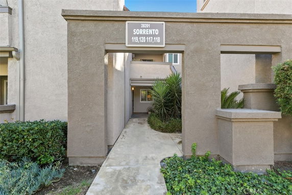 Front view of a building entrance with a sign reading 'SORRENTO 119, 120, 117, 118' above the entryway.