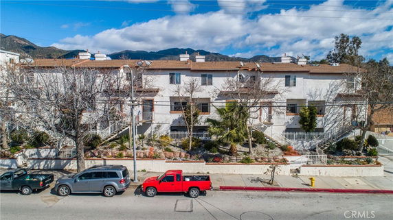 Front view of a multi-story condominium building with several entrances and balconies.