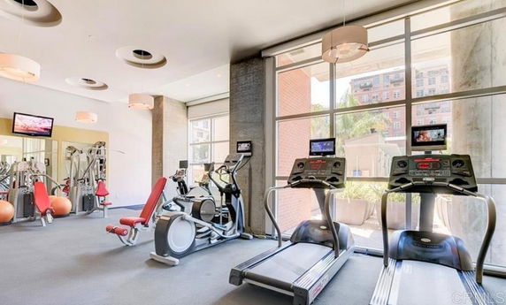 Gym area with exercise equipment and large windows.