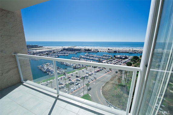 Panoramic view from a building showing a marina, coastline, and ocean.