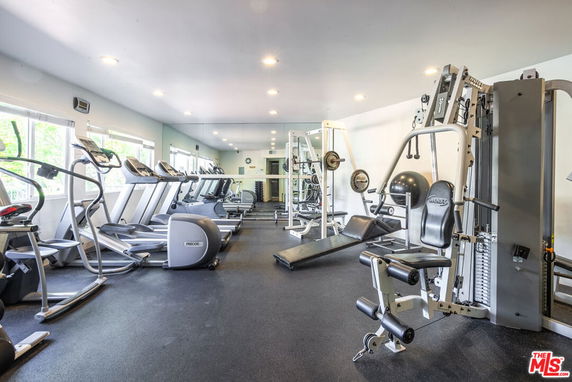 Indoor gym area with various exercise machines and equipment.