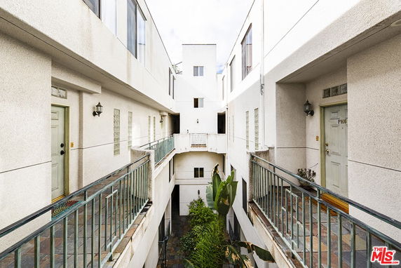 View of a multi-story building with balconies and doors.
