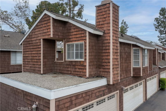 Front view of a house with shingle siding and multiple garage doors.