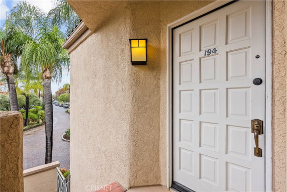 Entrance of a house with a numbered white door and wall light.