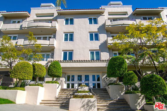 Front view of a multi-story residential building with balconies.