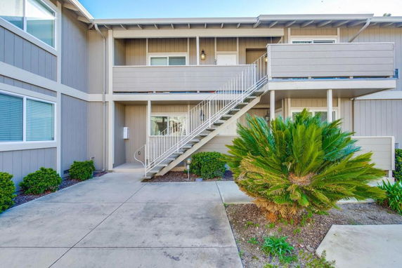 Front view of a two-story residential building with an exterior staircase.