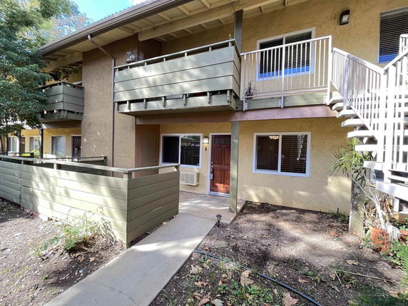 Front view of a two-story building with balconies and a shared entryway.
