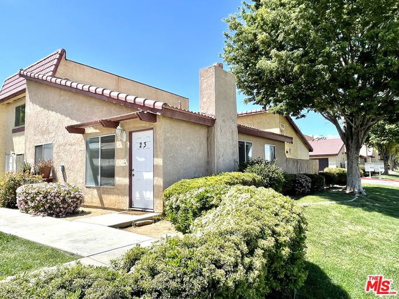 Front view of a single-story house with a tiled roof and a white door.