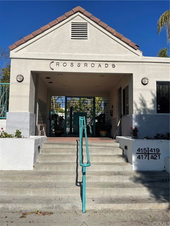 Front view of a building entrance with steps and a gable roof.