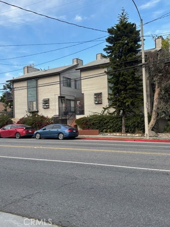 Front view of a two-story building with a flat roof and multiple balconies.