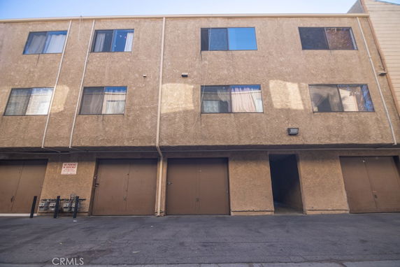 Front view of a multi-story building with garage doors on the ground level.