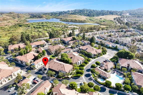 Aerial view of a residential area with rows of houses and a nearby body of water.