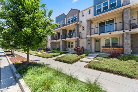 Front view of a multi-story townhouse with balconies.