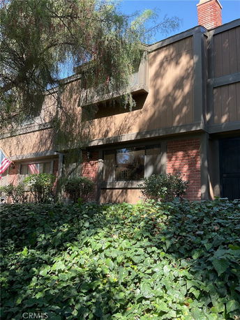 Front view of a multi-story house with brick and wood facade.