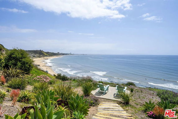 Panoramic view of a coastline with seating area overlooking the ocean.