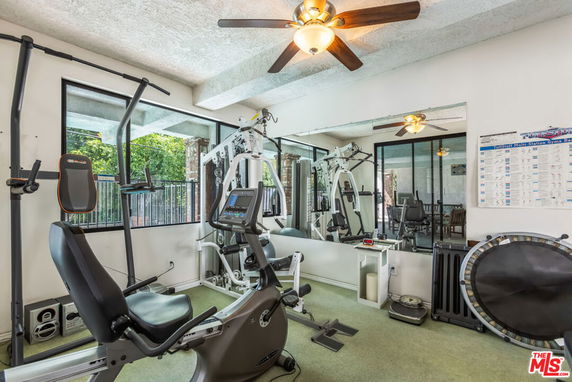 Indoor gym area with exercise equipment and mirrored wall.