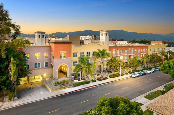 Front view of a multi-story apartment building with colorful facades and arched entrance.