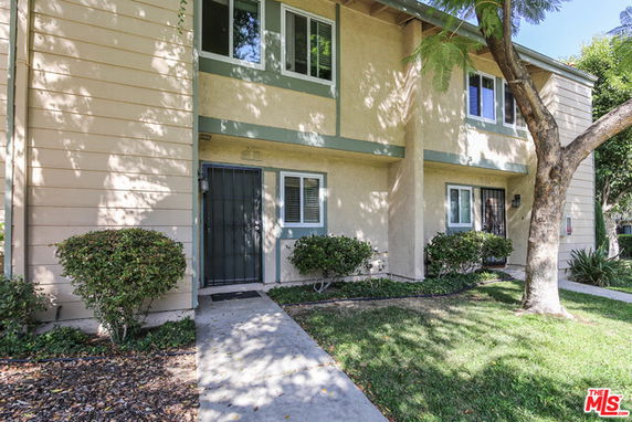 Front view of a two-story residential building with a pathway leading to the entrance.
