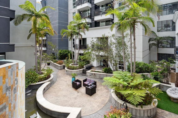 View of an outdoor courtyard area with seating and plants in a multi-story residential building.