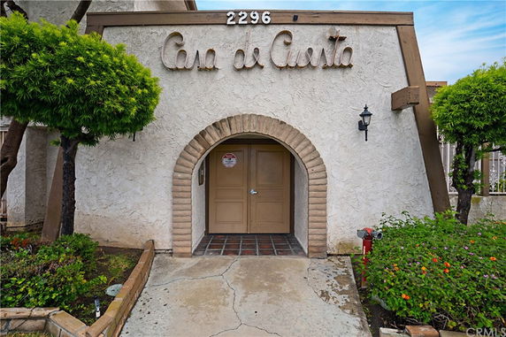 Front view of a building entrance with an arched doorway and decorative signage.