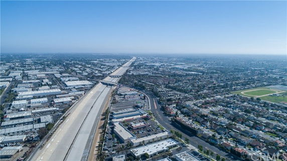 Panoramic view from above showing buildings and a highway extending into the distance.