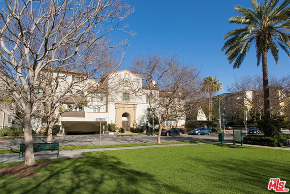 Front view of a multi-story building with an arched entrance.