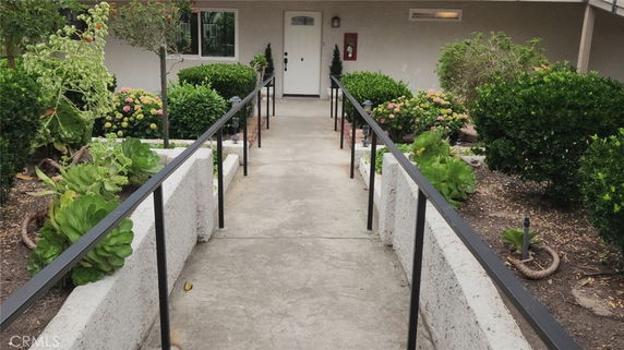 Front view of a building entrance with a walkway and garden.
