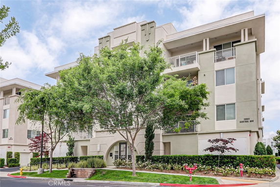 Front view of a multi-story apartment building with balconies.