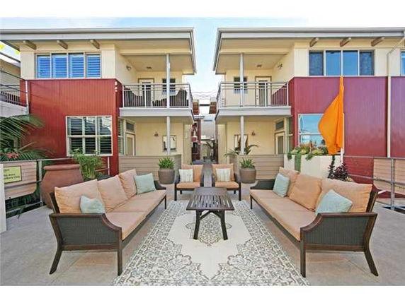 Front view of a modern two-story building with balconies and outdoor seating area.